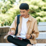 man sitting reading book stairs